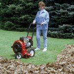 A woman in a field using a Merry Commercial leaf blower