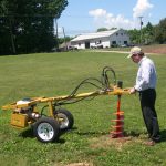 Man using an Easy Auger Hydraulic Earth Drill and Post Hole Digger
