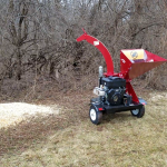 Wood chips spraying out of merry commercial wood chipper WC45