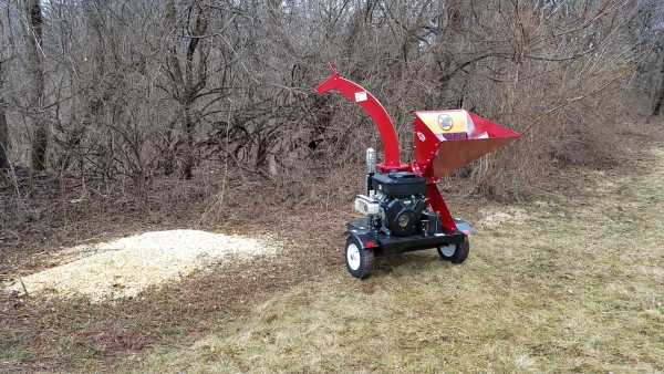 Wood chips spraying out of merry commercial wood chipper WC45