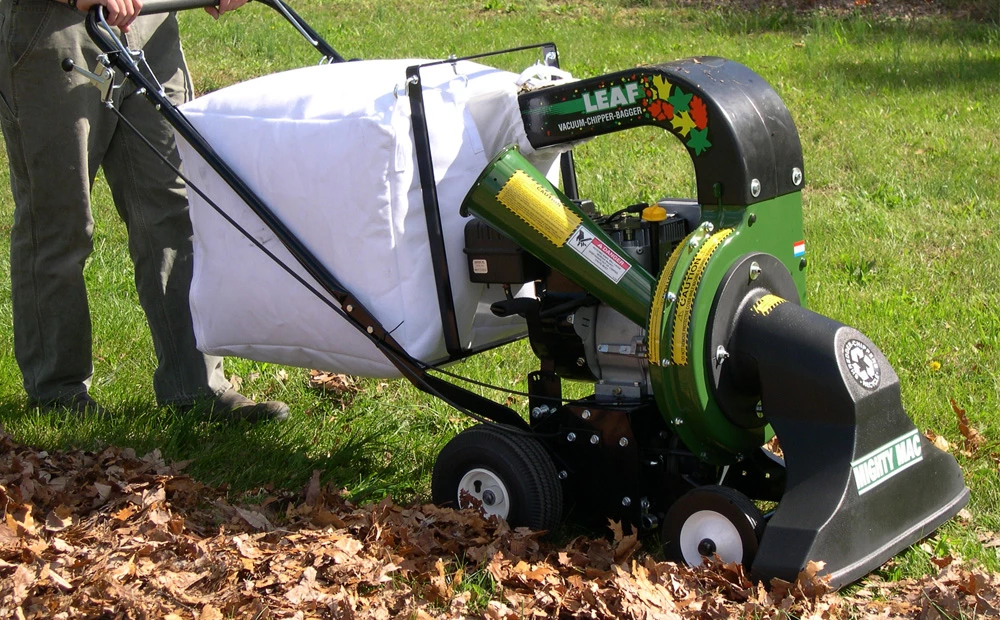 mackissic leaf vacuum chipper-bagger being manually pushed while sucking up leaves
